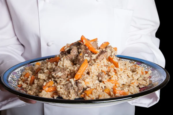 Prato turco com pilaf nas mãos do cozinheiro — Fotografia de Stock