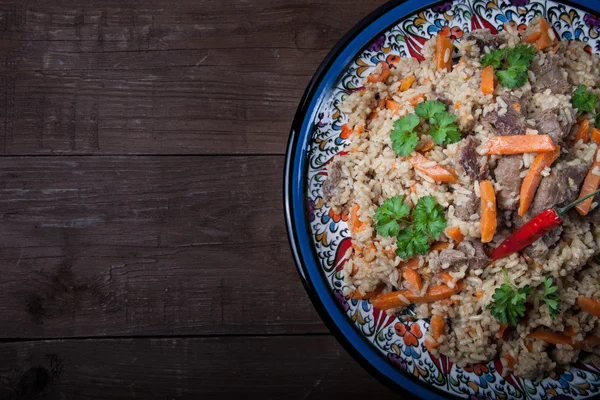 Delicious pilaf on a turkish plate on old wooden table. Rustic s — Stock Photo, Image