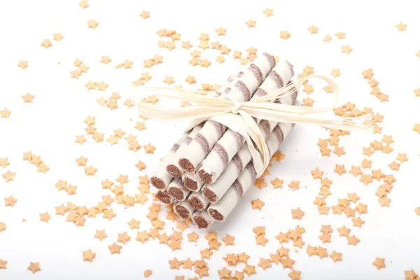 Tubi cialde con crema di cioccolato su sfondo bianco con stelle — Foto Stock