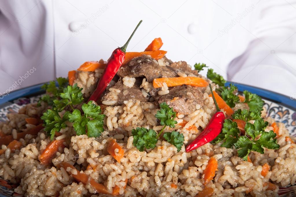 Turkish dish with pilaf in the hands of the cook
