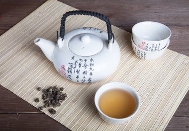 Çaydanlık, fincan yeşil çay ve çay bir peçeteye bambo bırakır