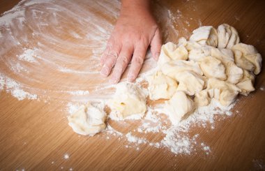 Baker ahşap bir masa üzerinde pişmemiş hamur kneads