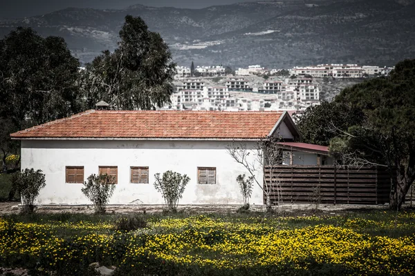 Haus auf der Wiese mit Blick auf die Stadt. getönt — Stockfoto