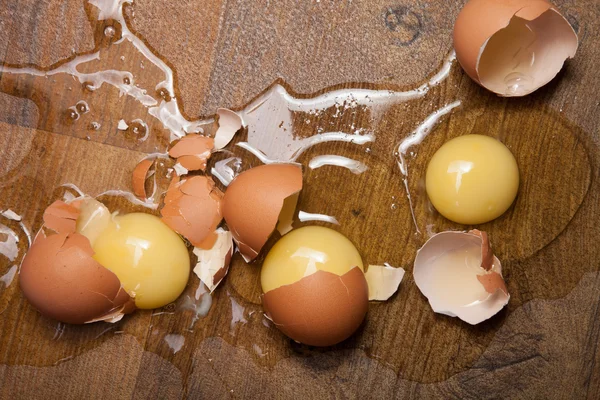 Broken eggs on the wooden floor — Stock Photo, Image