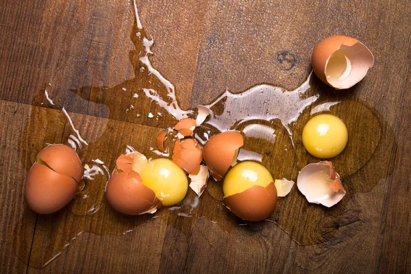 Broken eggs on the wooden floor — Stock Photo, Image