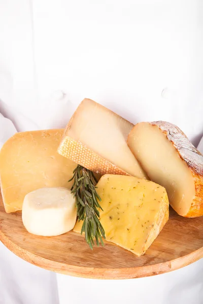 Planche à découper avec différents types de fromage dans les mains de la — Photo