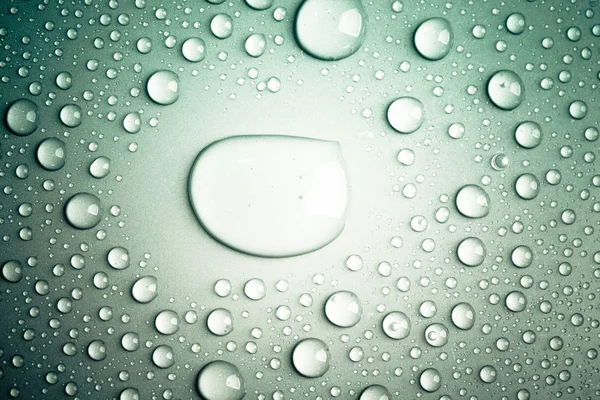 Gotas de água em um fundo a cores. Profundidade de campo rasa — Fotografia de Stock