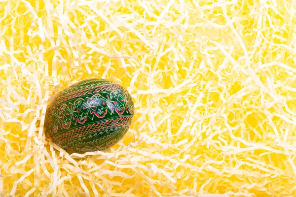 Painted easter egg in paper straw. Toned — Stock Photo, Image