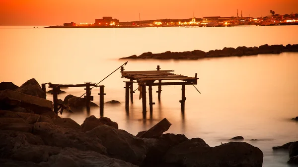 Západ slunce nad město Paphos s nefunkční pier — Stock fotografie