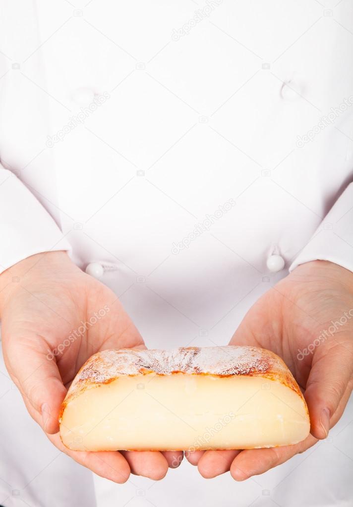 Rustic handmade gourmet cheese in the hands of the cook