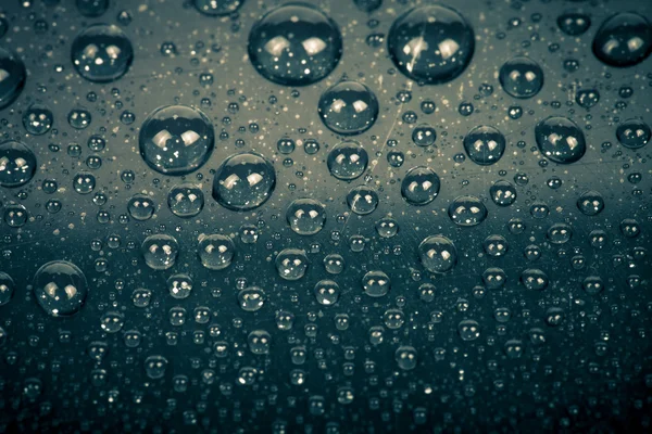 Gotas de água em um fundo a cores. Cinza. Profundidade rasa de fie — Fotografia de Stock