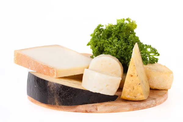 Olika typer av ost och en kvist persilja på en nedskärning av trä — Stockfoto