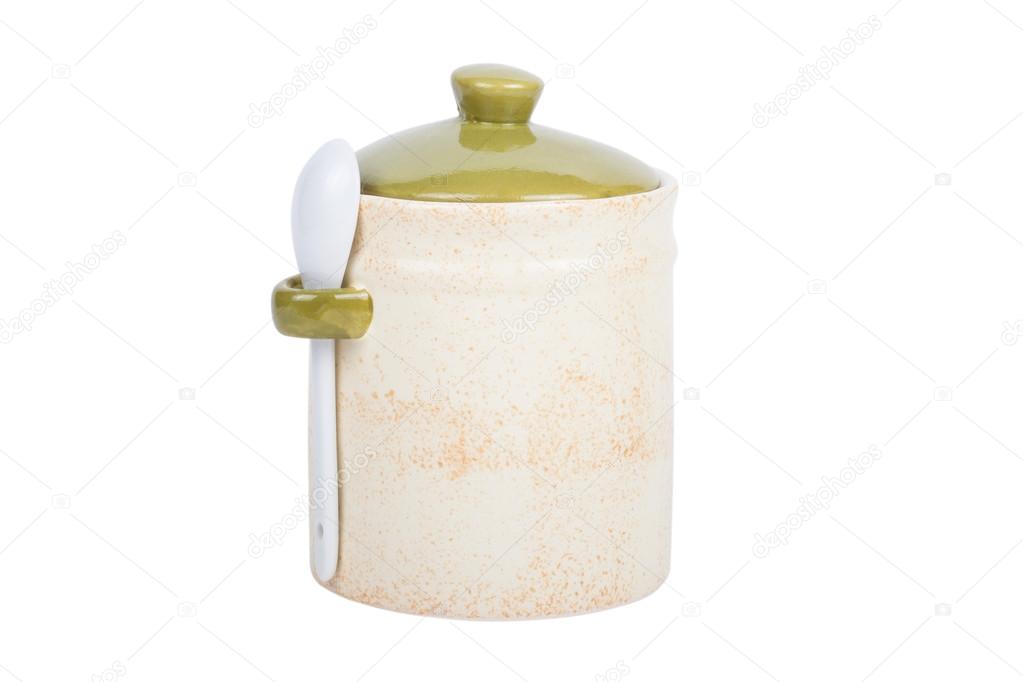 Ceramic jar for spices with a spoon on a white background