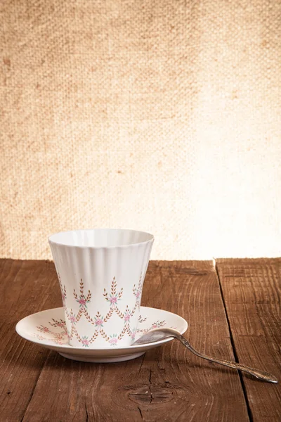 Kaffeetasse und Untertasse auf einem alten Holztisch. Hintergrundbild — Stockfoto
