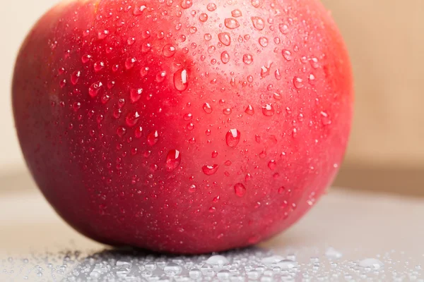 Manzana roja húmeda con gotas de agua en el fondo brillante — Foto de Stock