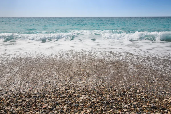 Espuma de olas marinas en la playa de guijarros — Foto de Stock