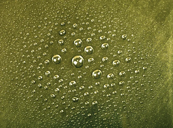 Druppels van het water op een achtergrond in kleur. groen. ondiepe diepte voor fi — Stockfoto