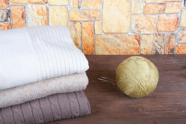 Empilement de vêtements à tricoter et boule de fil avec aiguilles à tricoter — Photo