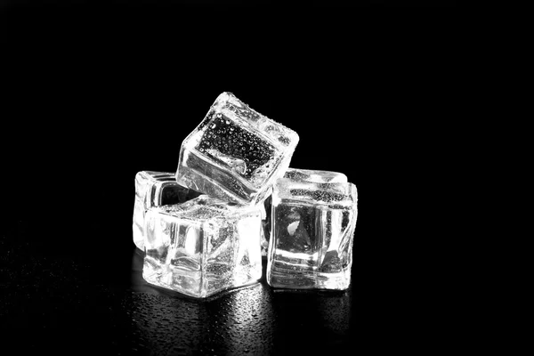 Cubos de gelo na mesa molhada preta. Foco seletivo — Fotografia de Stock