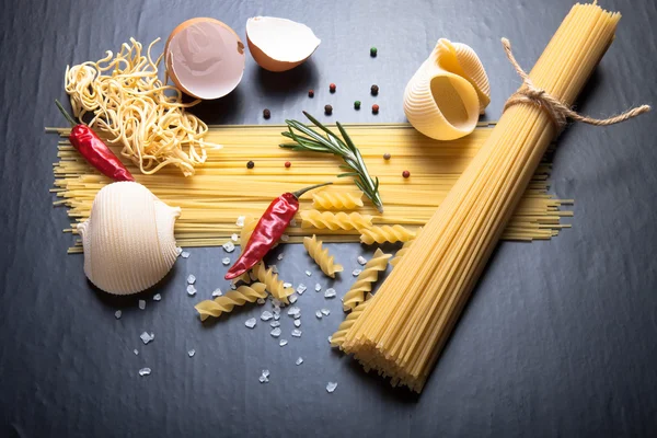 Different kinds of pasta, red chili pepper, rosemary, sea salt a — Stock Photo, Image