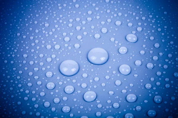 Gotas de agua sobre un fondo de color. Azul. Profundidad superficial de fie —  Fotos de Stock