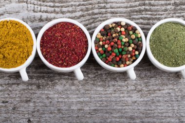 Eski ahşap baharat çeşitleri ile beyaz seramik bardak 