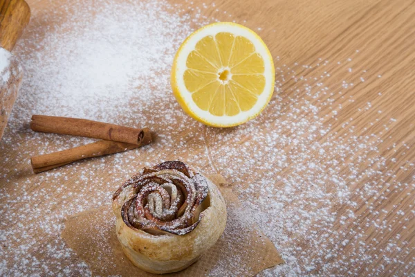 Homemade pastries on a light wooden table with flour