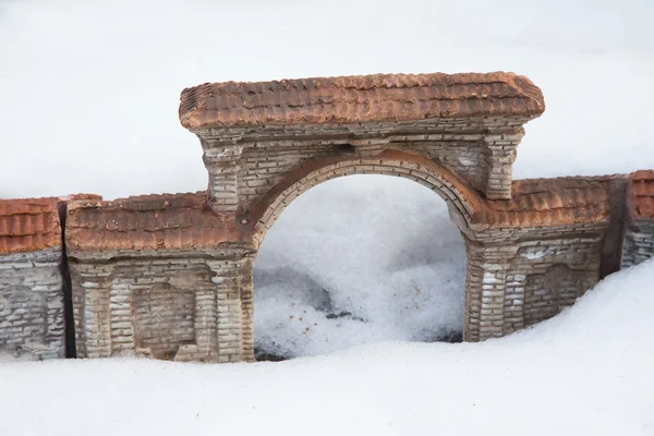 En miniatyr av den gamla tegelsten arch i snön — Stockfoto