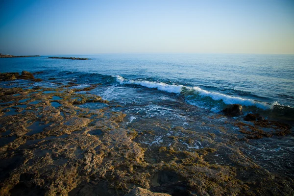 Olas marinas con espuma en la costa pedregosa. Tonificado — Foto de Stock