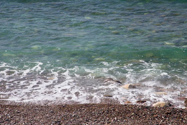 Mousse de vague de mer sur la plage de galets — Photo