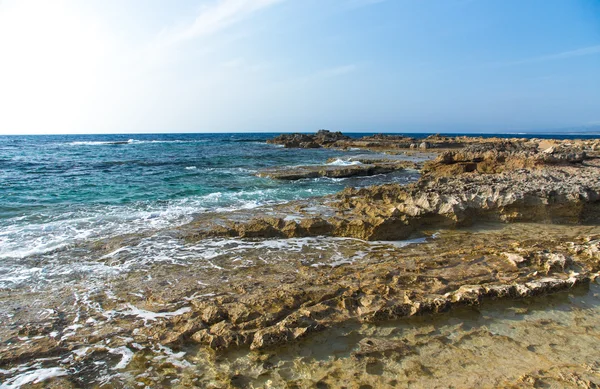 Onde marine con schiuma sulla riva pietrosa — Foto Stock