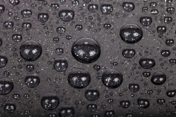 Gotas de água em um fundo a cores. Cinza. Profundidade rasa de fie — Fotografia de Stock