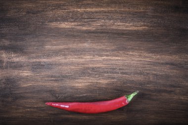 Red hot chili pepper on brown background. Toned