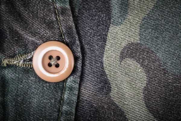 Zak met een knop op de stof met een camouflage patroon. BA — Stockfoto