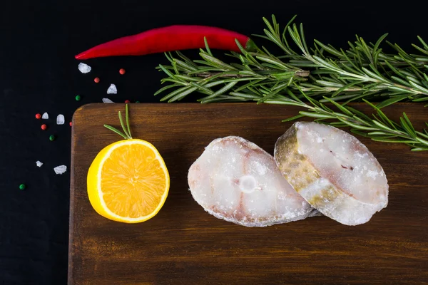 Fish steaks, rosemary, red chili pepper, half a lemon and sea sa — Stock fotografie