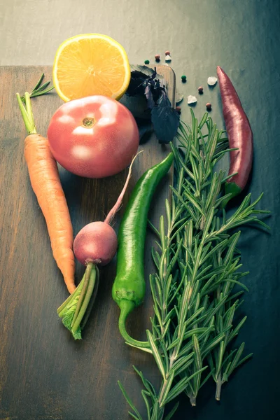 Vegetables and herbs with sea salt on brown cutting board on a b — Stock Photo, Image