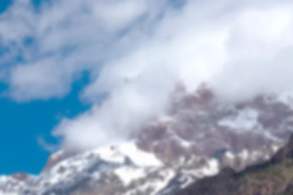 Abstraktes unscharfes Bild, hohe schneebedeckte Berggipfel in einer Wolke — Stockfoto