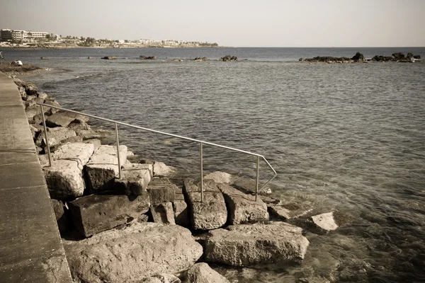 De rotsachtige helling naar de waterkant naar het water van de Mediterran — Stockfoto