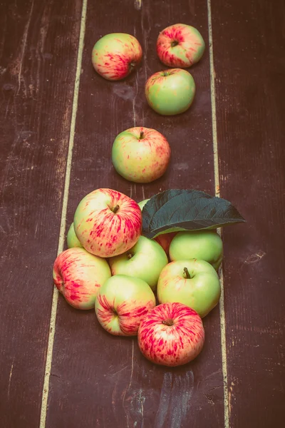 Žlutá červená sezónní jablka s listy na pozadí staré bo — Stock fotografie