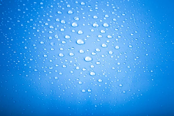 Gotas de agua sobre un fondo de color. Azul. Profundidad superficial de fie — Foto de Stock