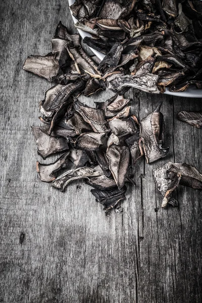 Pezzi di funghi porcini secchi su piatto di ceramica su vecchio grigio w — Foto Stock