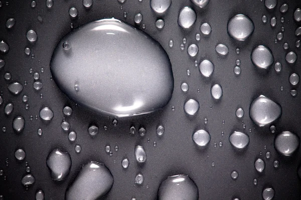 Gotas de água em um fundo a cores. Cinza. Profundidade rasa de fie — Fotografia de Stock