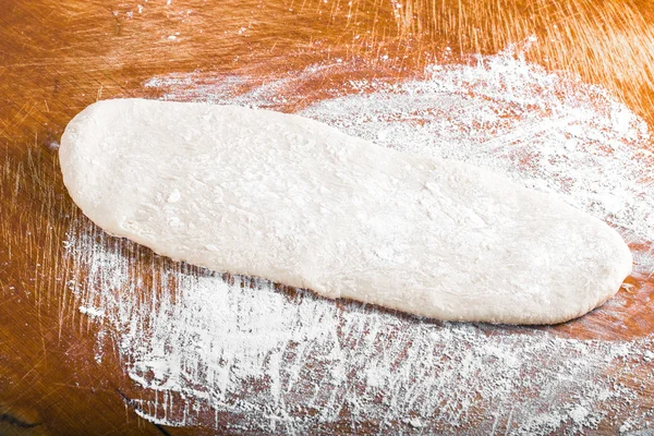 Laghman dough on an old wooden worn board with flour. Toned — Stock Photo, Image