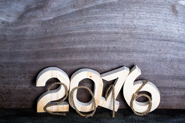 Cuerda y figuras de madera clara 2016 sobre fondo de madera gris en — Foto de Stock