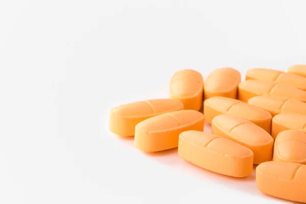 Куча оранжевых таблеток на светлом фоне. Toned — стоковое фото