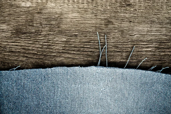 Texturerat bakgrund av två material - hälften är blå jeans och ha — Stockfoto