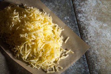 Backgr gibi gri taş masada waxlı kağıt üzerine rendelenmiş peynir