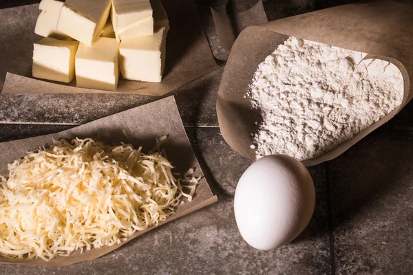 Ingredienser för bakning på pergament papper på grå sten tabell li — Stockfoto