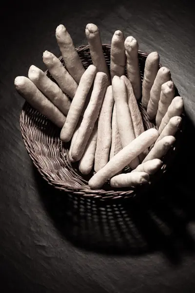 Свежий сыр палочки в плетеной деревянной корзине на черный счет — стоковое фото
