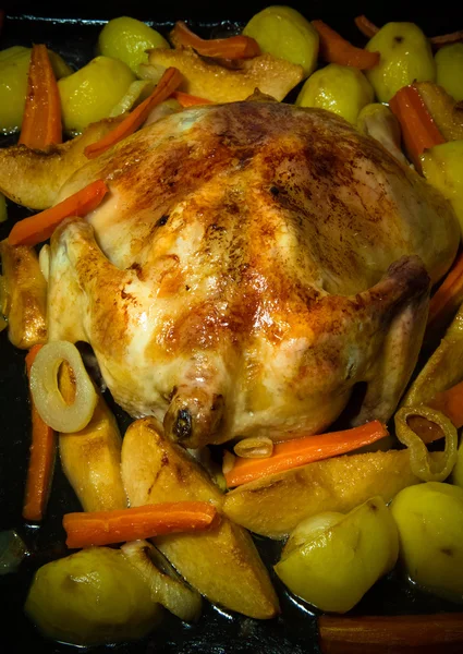 Fried chiken with vegetables on a pan on a black wooden table. T — Stock Photo, Image